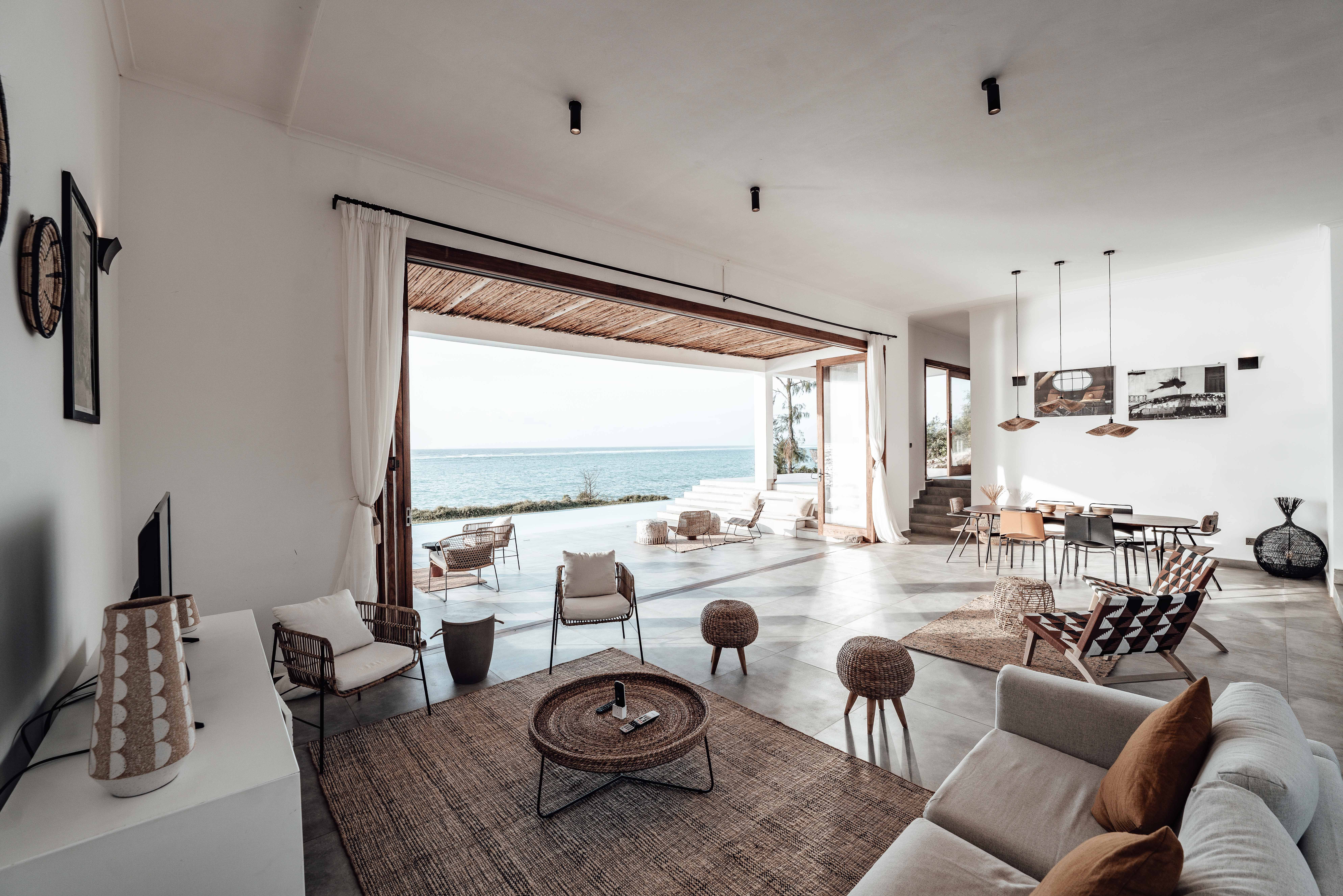 Stock photograph of an airy living room opening towards the sea; inspiration for the Marea House concept